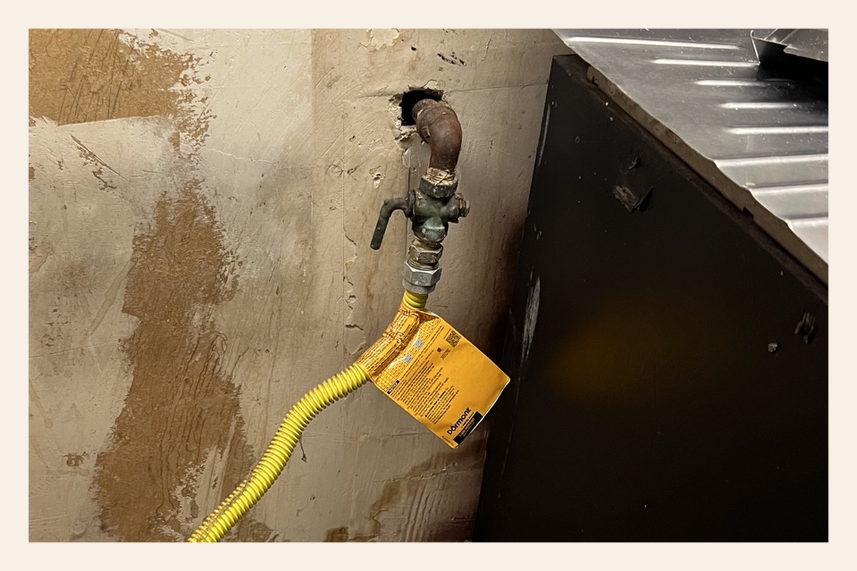 Later photograph of the gas connection behind the stove