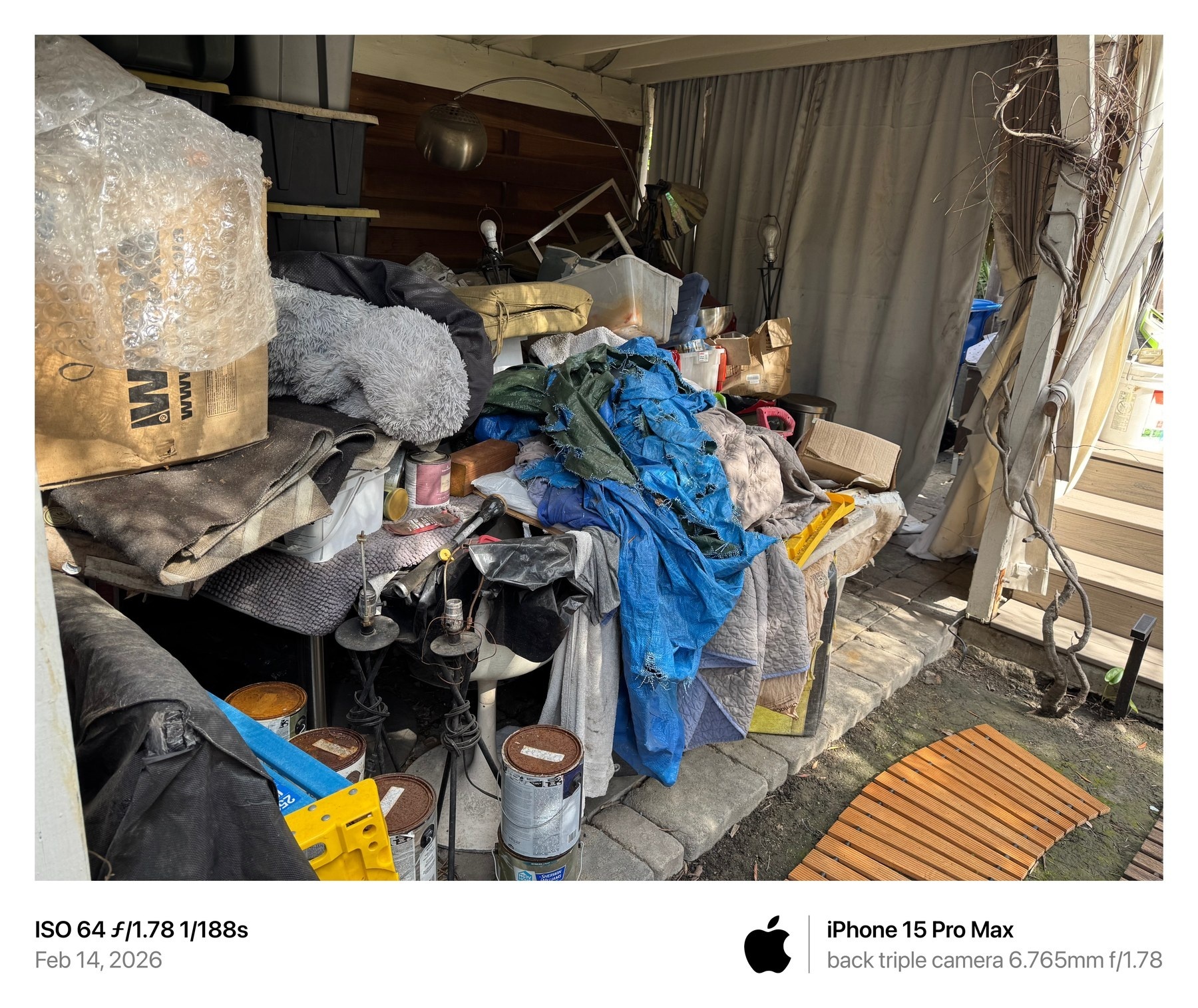 February 14, 2026 photograph showing rotting material, paint cans, and piled belongings beside the dwelling