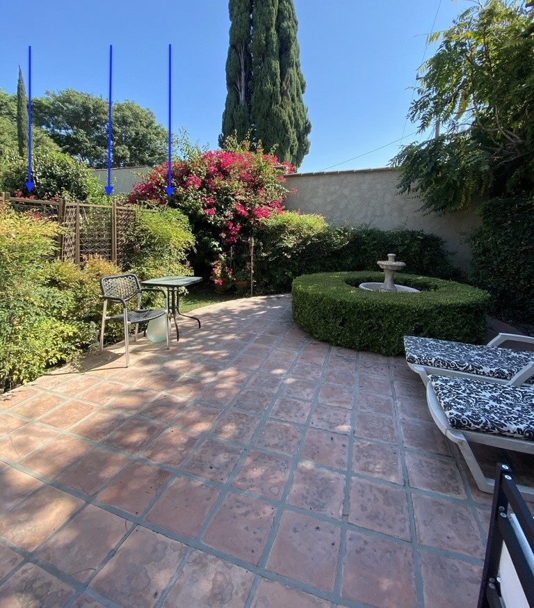 The patio attached to the unit, with blue arrows marking the former privacy-fence line.